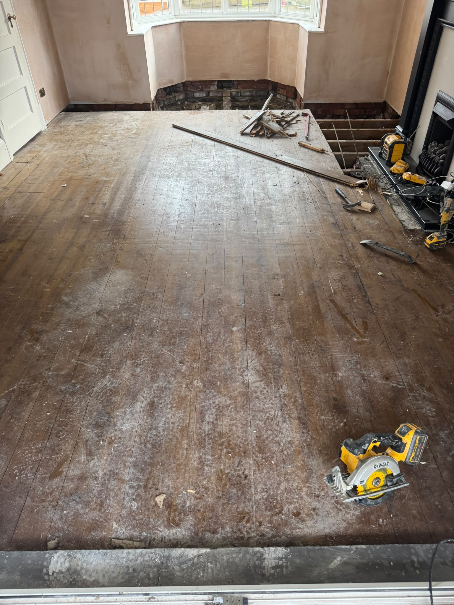 Original floorboards exposed and repaired during a living room renovation