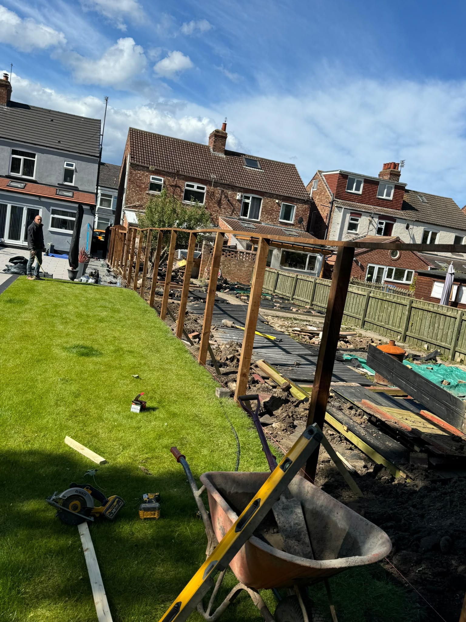 Garden mid-transformation with new lawn laid and fence posts going in