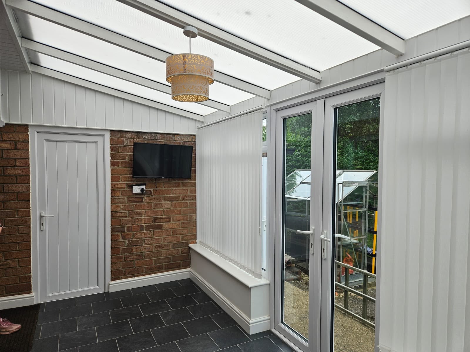 Before — inside the old conservatory, with its polycarbonate roof and plastic cladding