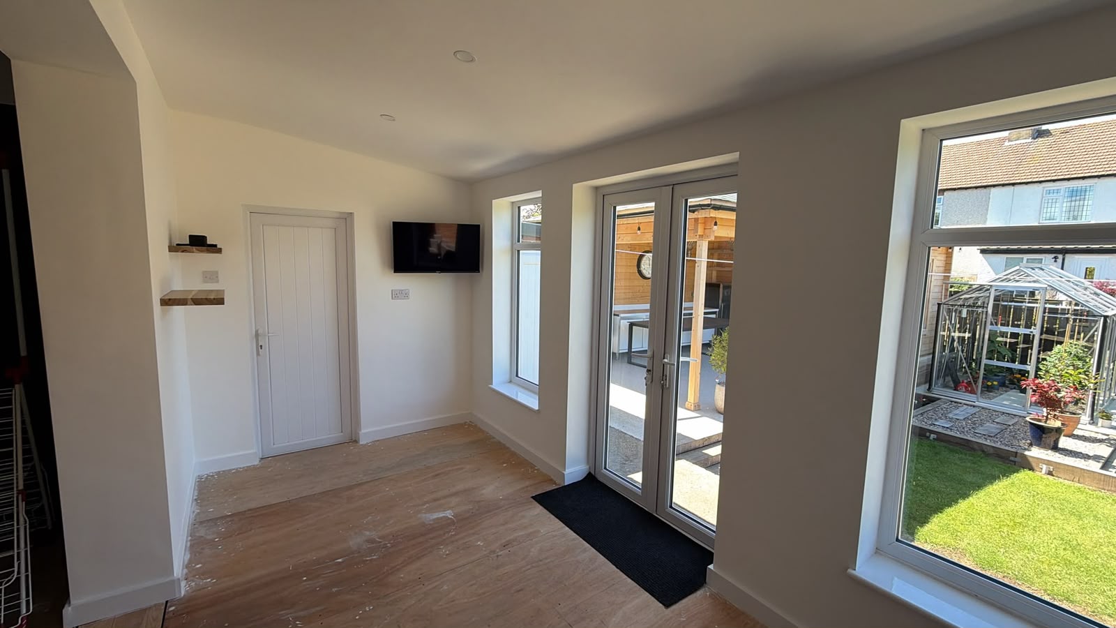 After — the finished room, plastered and decorated, opening onto the garden