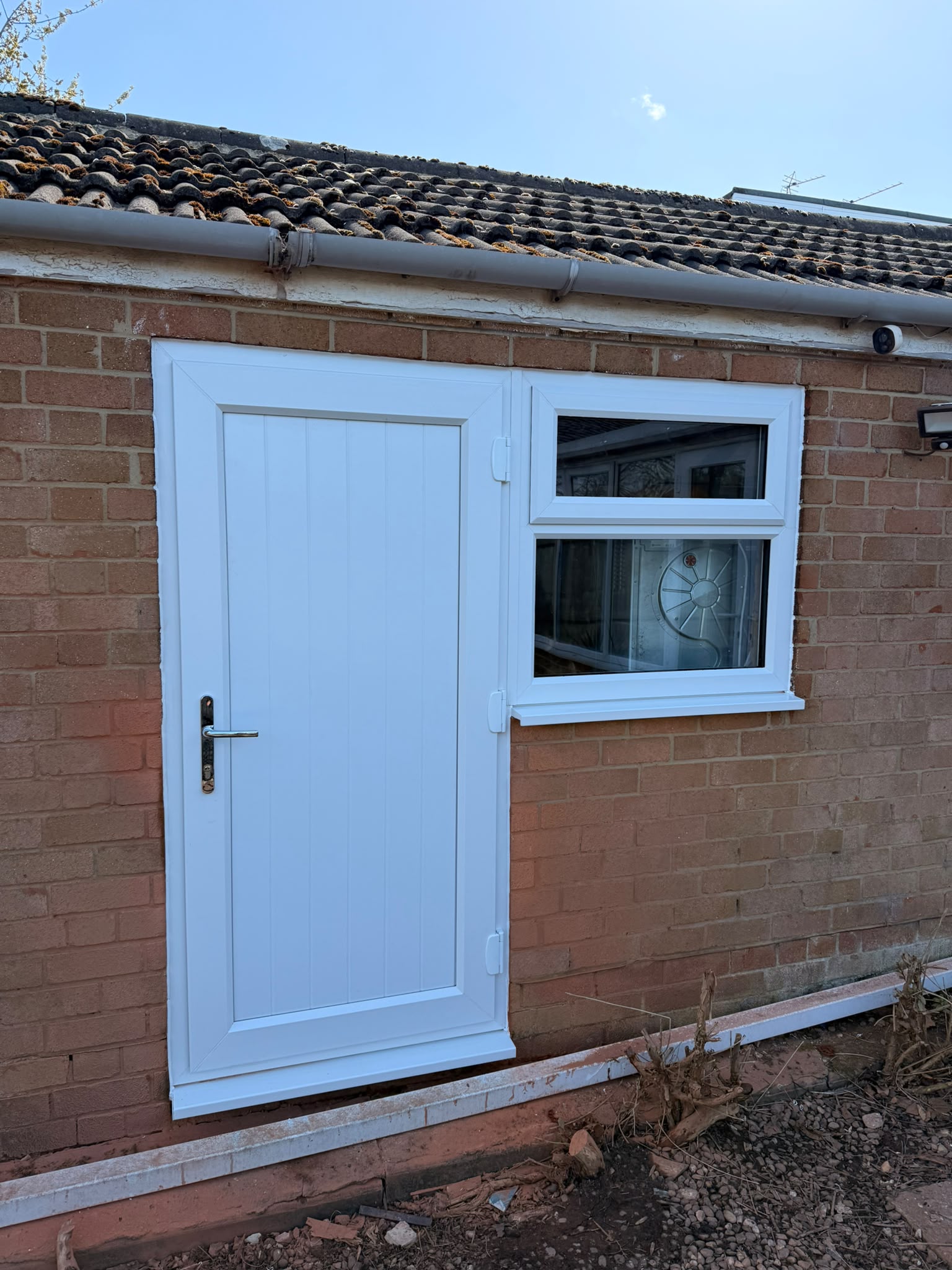 The new white door and matching window fitted into the garage wall in Eston