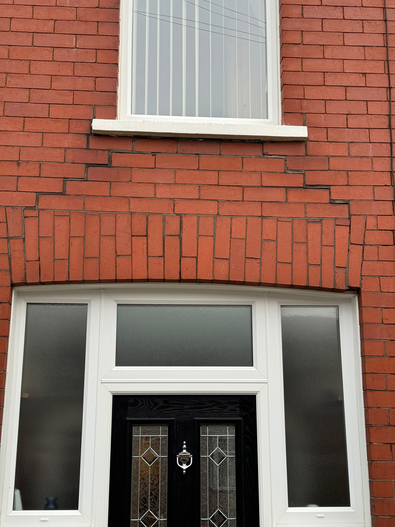 The failed arch above the doorway, with cracking through the brickwork