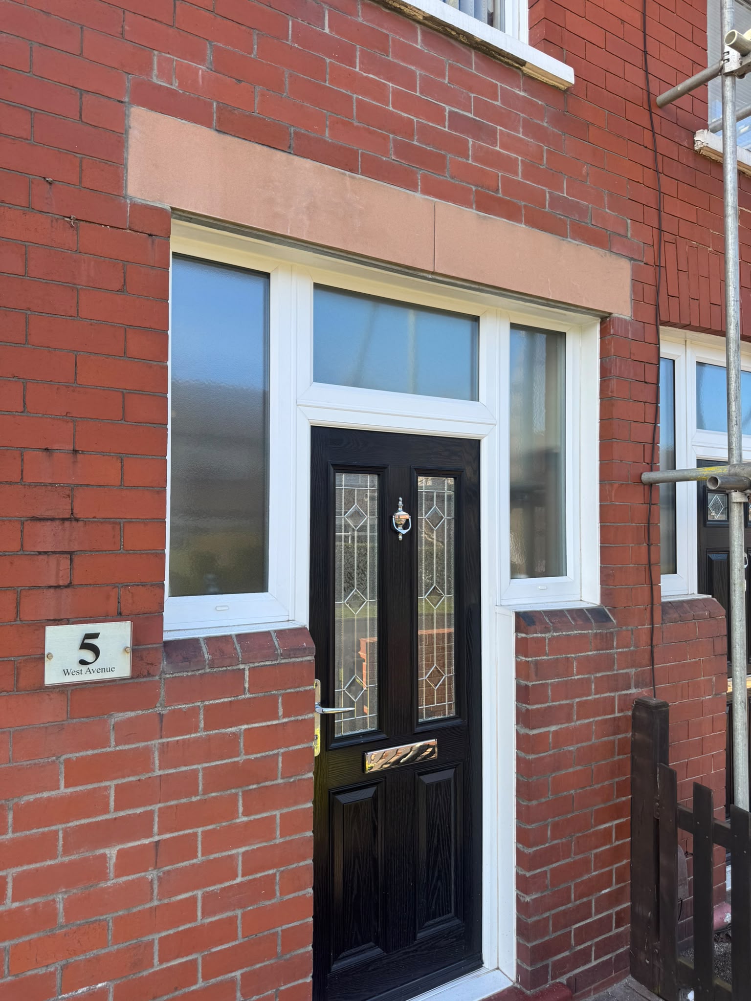 The rebuilt brickwork and new sandstone lintels above the front door